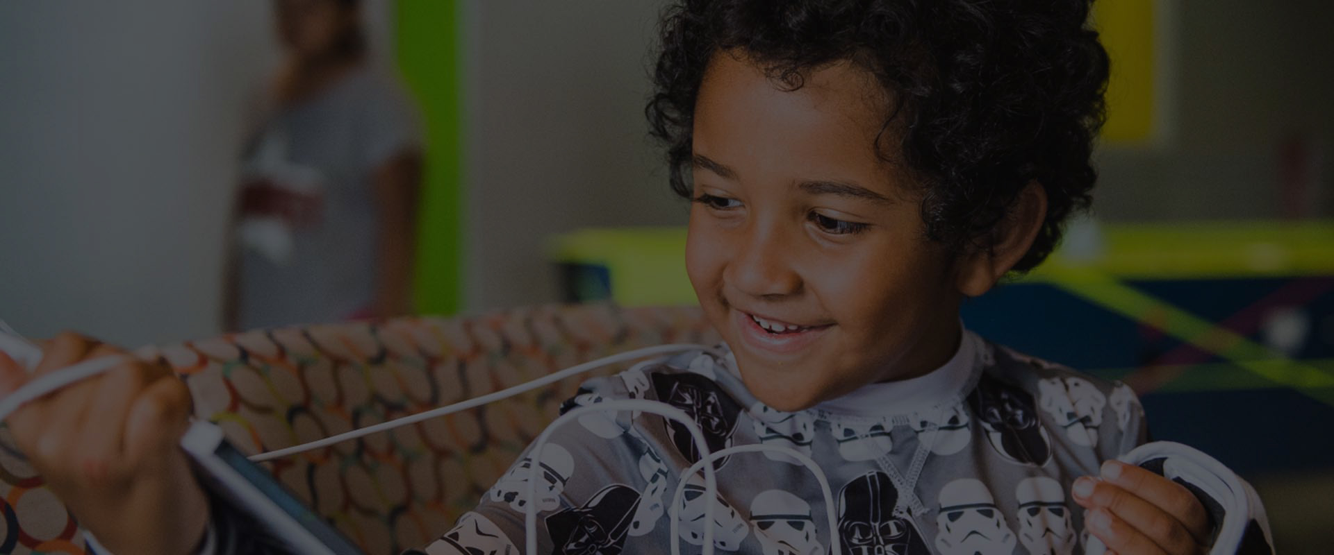 A child in a hospital bed playing — focused, joyful, in control of the game